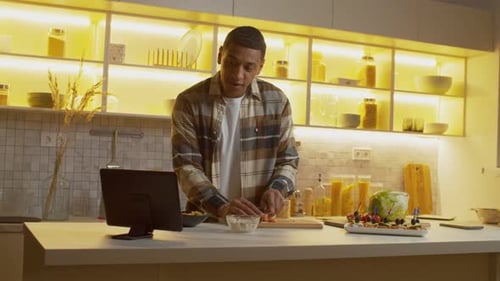 Young Adult Prepares Food in a Modern Kitchen