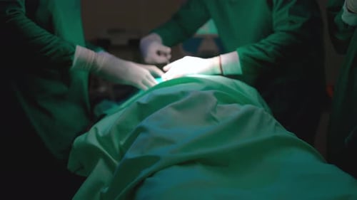 Nahaufnahme operierender Arzt und Krankenschwester mit Spezialbrille führen den Operationsprozess des Patienten durch