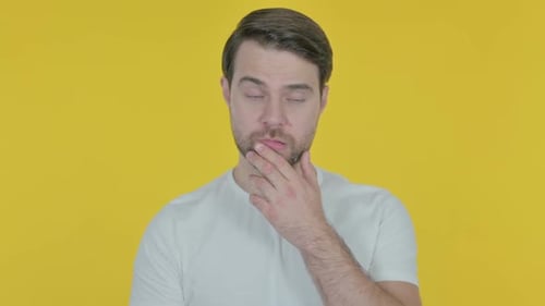 Pensive Young Man Thinking and getting Idea on Yellow Background