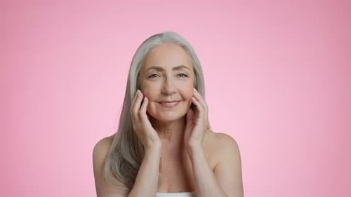 Elegant Senior Woman Massaging Her Face Smiling