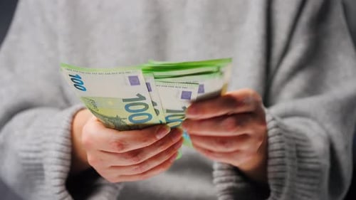 Крупный план женщины, считающей купюры в евро