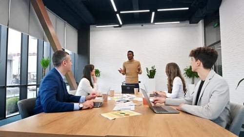 Black male team leader at business meeting in an office, discussing business affairs with other work