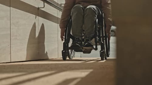 Man in Wheelchair Using Ramp at Entrance of Building