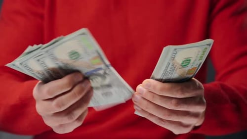 Hands Counting Stack of United States Currency
