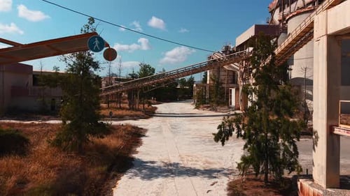 Abandoned Industrial Factory with Rusty Conveyor Belts and Decaying Concrete Silos