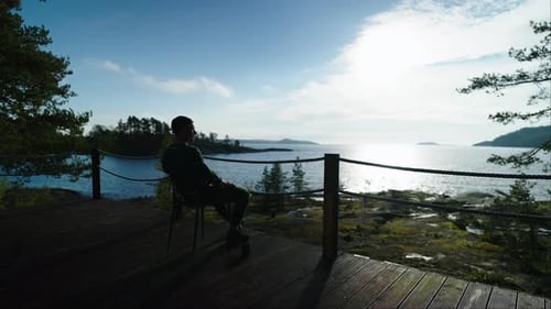 Alone Man Sitting On Balcony And Admiring Beautiful View On Landscape With Lake Dark Silhouette