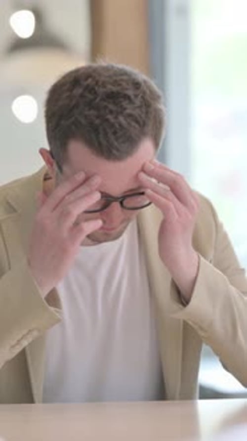 Young Man Rubbing Temples Due to Headache