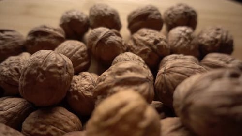 Close Up of Plump Brown Walnuts on Wood