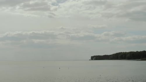 A Tranquil and Picturesque View of Calm Waters Gently Meeting the Cloudy Skies Above a Stunning