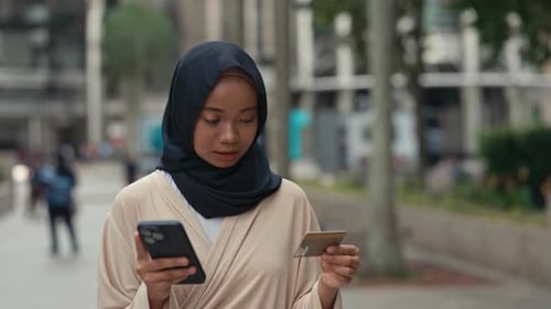 Woman with Smartphone and Credit Card in City