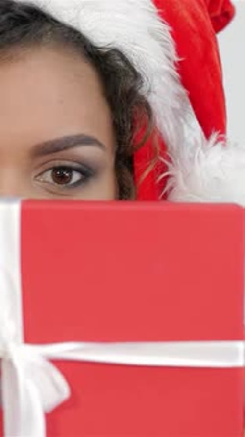 Woman in Santa Hat Holding Christmas Gift
