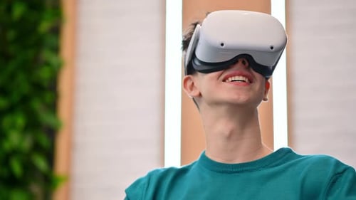 A young excited caucasian man exploring virtual reality using VR glasses in an office