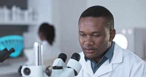 Man Using Microscope in Bright Laboratory