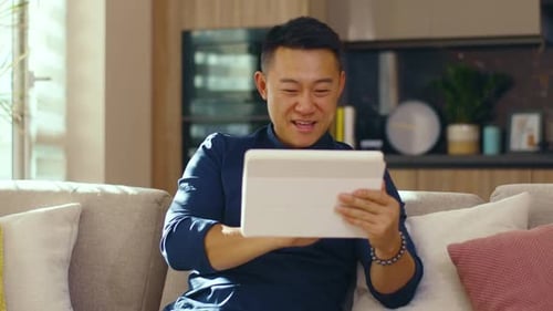 Man Using Tablet Device on Sofa