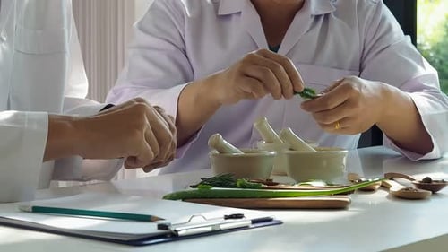 The scientist or doctor make herbal medicine from herb in the laboratory on the table.