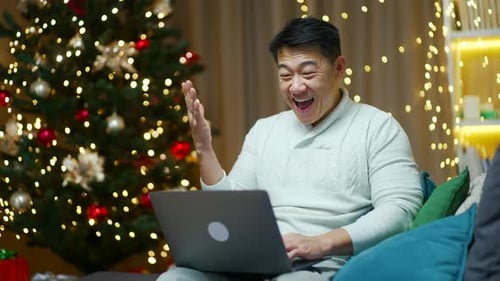 Man Celebrates Success Using Laptop at Christmas
