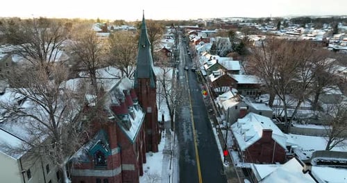 Lititz Pennsylvania in winter snow. Aerial pass by steeple at Linden Hall School. Beautiful sunset g