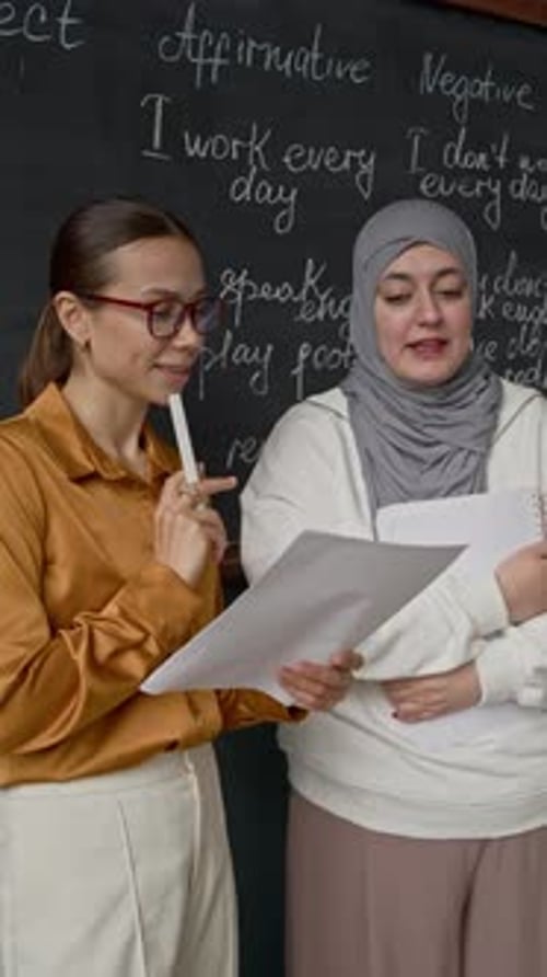 Two Women Collaborating on English Lesson in Classroom