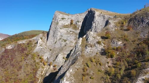 Flying over limestone cliffs and autumn forest aerial view