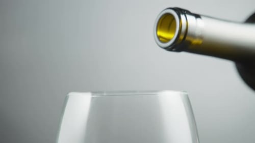 Du vin blanc est versé hors de la bouteille