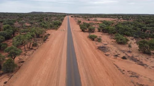 Drone ascending over a very strait country road in the Australian Outback