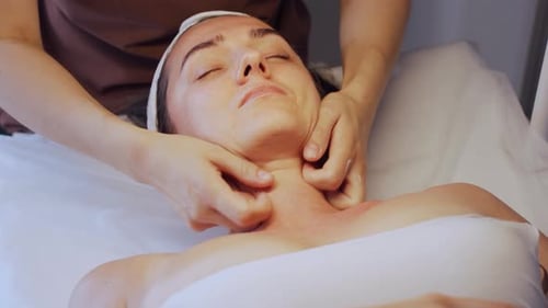 Woman Receiving a Facial Massage at a Spa