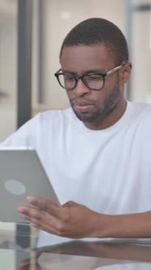 Focused Man Uses Tablet Device in Modern Office