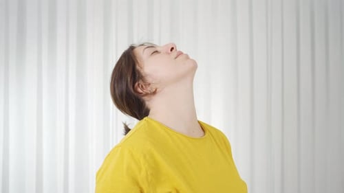 Woman Rotates and Stretches Neck for Wellness