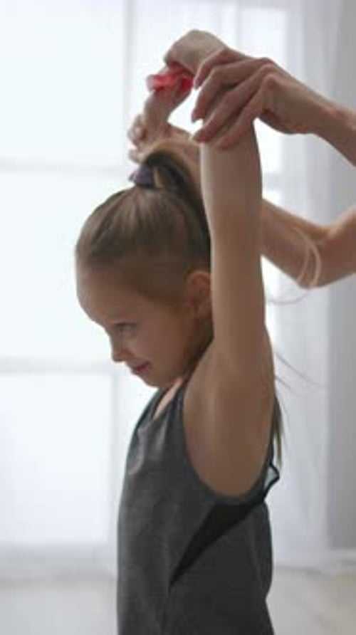 Little Girl Receiving Shoulder Physiotherapy with Elastic Resistance Band in Bright Home Setting