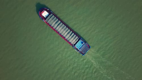 Barge Travels on the River at Daytime in China Carrying Cargo Under Cover