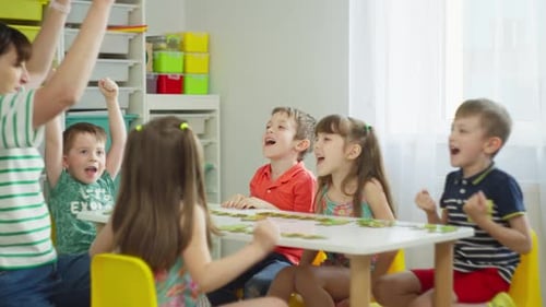Children and Teacher Solve Puzzle Together at Table