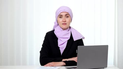 Muslimische Geschäftsfrau im Hijab lächelt und blickt in die Kamera