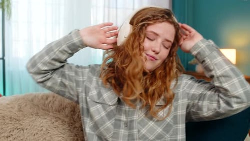 Woman Listening to Music on Headphones at Home