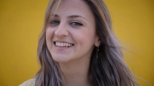 Smiling Woman in Front of Yellow Background