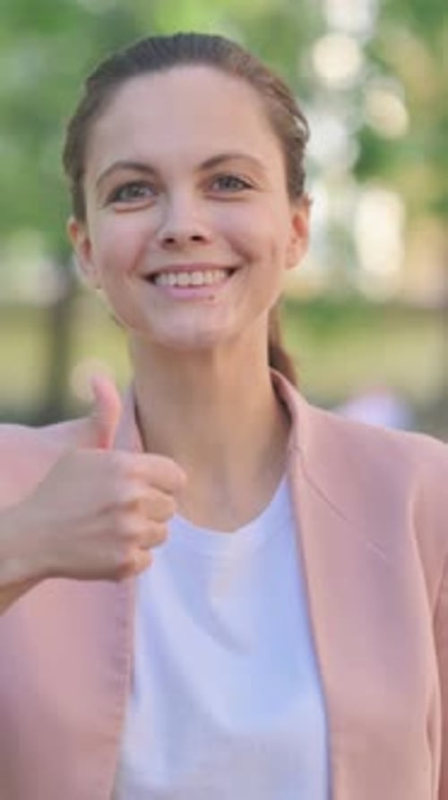 Cheerful woman smiling and giving a thumbs up
