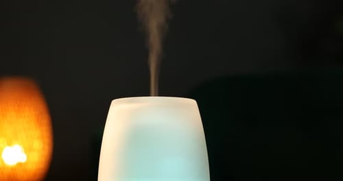 Essential Oil Diffuser Emitting Steam in a Dark Room