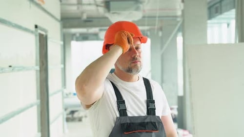 Portrait of a Confident 50s Builder in Safety Hardhat on the Construction Site