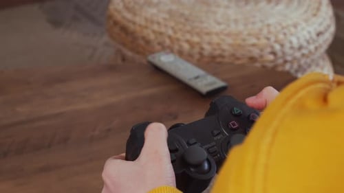Kid holding controller joystick to play video game on home video game console