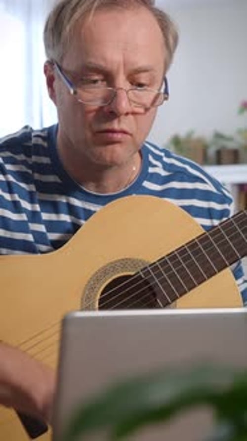 Un homme d'âge moyen jouant de la guitare acoustique