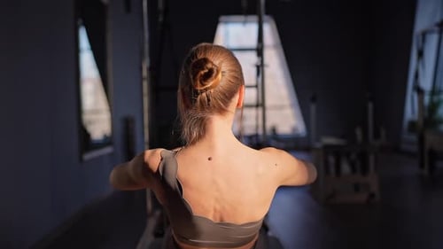 Woman Exercising on Pilates Machine in Fitness Studio