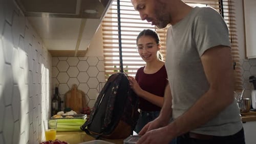 Caucasian father giving a lunch box to daughter to school. Shot with RED helium camera in 8K.