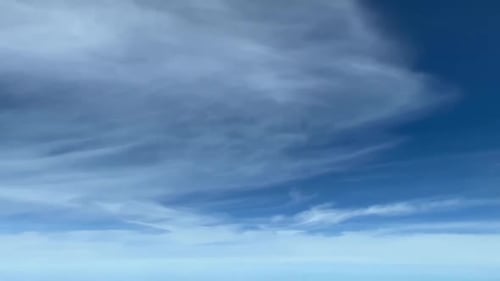 Quelques nuages mêlés dans un ciel bleu pris depuis un poste de pilotage