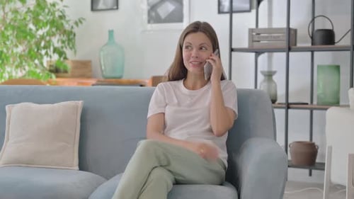 Woman Talking on Cell Phone Sitting on Couch