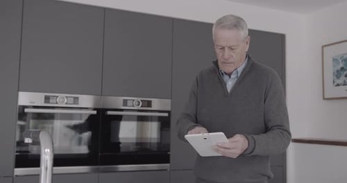 Man Using Tablet Device in Modern Kitchen