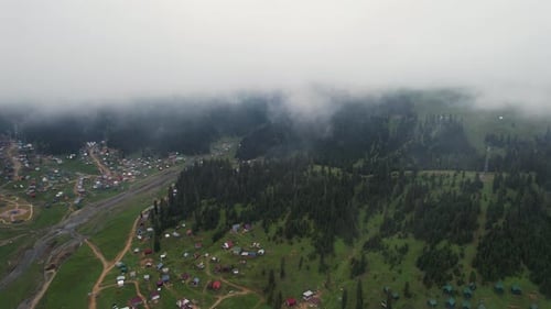 Mountain village landscape through the clouds. Fog in mountains background.