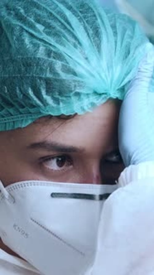 Medical Professional Puts on Protective Surgical Gear