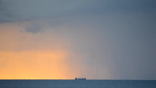 A Graincarrier Tankers is Far Away on the Horizon Line in the Sea on Background