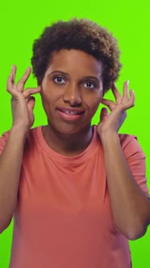Jeune femme exprimant sa surprise devant un fond vert vif