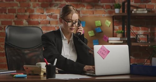 Young Businesswoman in Office with Brick Wall Background