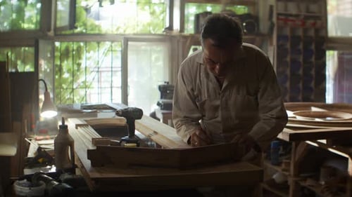 Focused Man Crafting Woodwork in Workshop